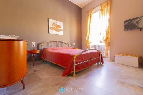 sypialnia z czerwonym łóżkiem i oknem w obiekcie Dimora di Halem w mieście Lecce