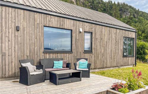 a patio with two chairs and a table and a building at 4 Bedroom Nice Home In Stangvik in Stangvik