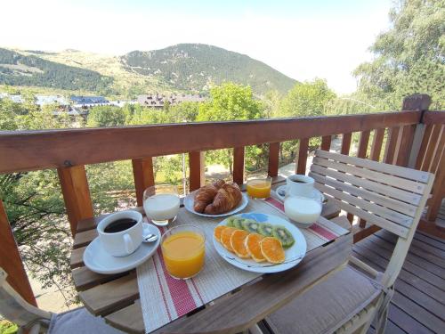 a table with breakfast foods and drinks on a balcony at UNIQUE EXPERIENCE - Boí-Taüll Apartment in Pla de l'Ermita