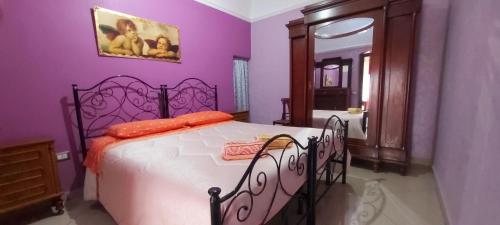 een slaapkamer met een wit bed met paarse muren bij INTERNO 13 Apartament in Spinazzola