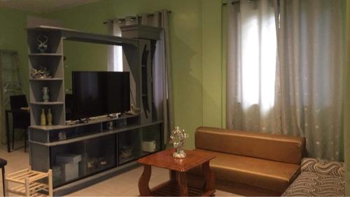 a living room with a couch and a tv at Brown Gate House in Panabo