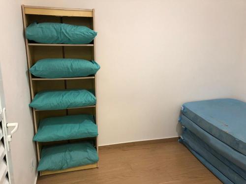 Zimmer mit vier grünen Kissen und einem Bett in der Unterkunft Apartamento beira mar - Praia de Boraceia in Bertioga