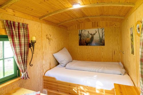 a room with two beds in a tiny house at Jägerwagen - Im Herzen des Unterallgäus in Erkheim
