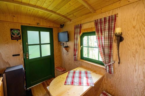 una piccola camera con una porta verde e una finestra di Jägerwagen - Im Herzen des Unterallgäus a Erkheim