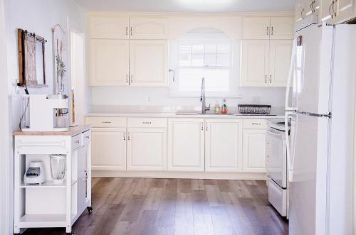 Il comprend une cuisine blanche avec des appareils électroménagers blancs et du parquet. dans l'établissement Cozy Cottage Retreat in the Heart of Utah Valley, à Orem
