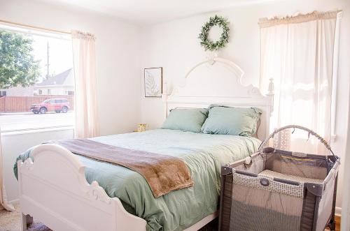 a bedroom with a white bed and a window at Cozy Cottage Retreat in the Heart of Utah Valley in Orem