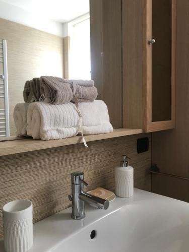 baño con lavabo y toallas en un estante en Tartaruga House, en Policoro