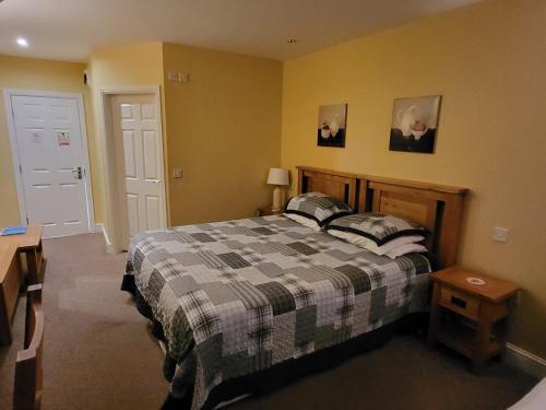 a bedroom with a bed with a checkered blanket at The Royal Inn in St Austell