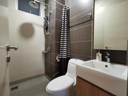 La salle de bains est pourvue de toilettes, d'un lavabo et d'un miroir. dans l'établissement Artsy Homestay in JB Town Center Near FoodCourt, Malls & Grocery, à Johor Bahru
