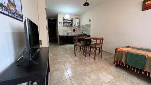 a living room with a table with chairs and a television at Departamento Centrico in Villa María