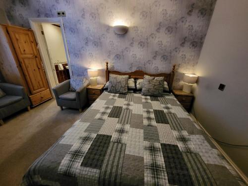 a bedroom with a large bed and two chairs at The Royal Inn in St Austell