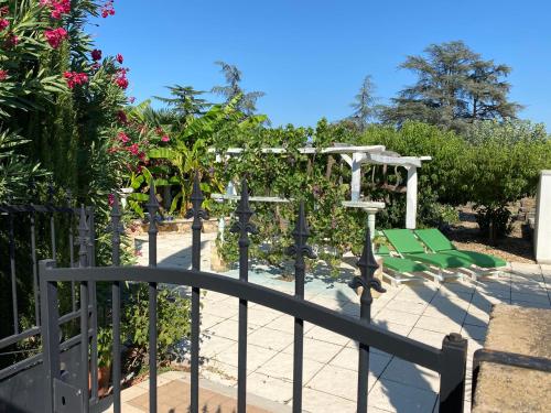 un patio con sillas verdes y una valla en Chambres privées dans maison avec grand parc et piscine proche Via Rhona, en Andancette