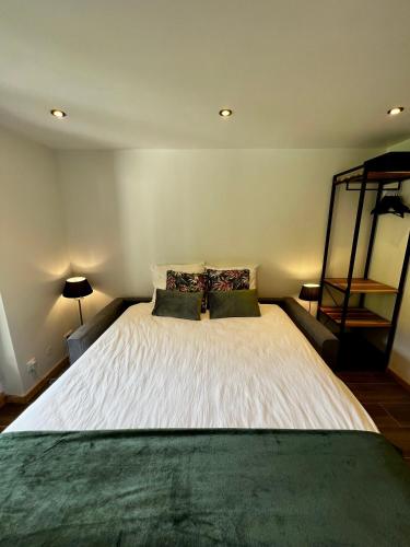 une chambre avec un grand lit blanc avec deux oreillers dans l'établissement Chez Naomi - Studio Mirjam, à Châtel