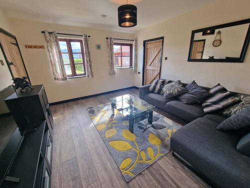 a living room with a couch and a glass table at Swallows Nest in Abergavenny