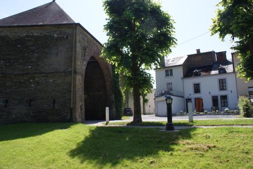 an old brick building with an arch in the grass at Café du Pêcheurs in Bouillon