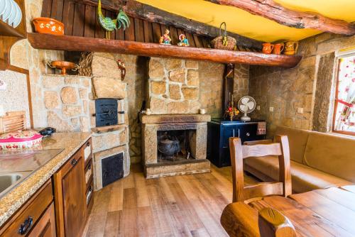 a kitchen with a stone fireplace in a room at Araújo 111 - Traditional House in Leça do Balio