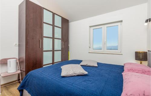 ein Schlafzimmer mit einem blauen Bett mit zwei Kissen darauf in der Unterkunft Nice Home In Marcelji With Jacuzzi, 2 Bedrooms And Wifi in Marčelji