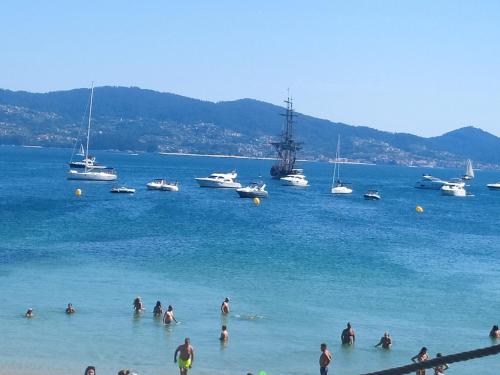 a group of people in the water at a beach at Casa Evita in Sanxenxo