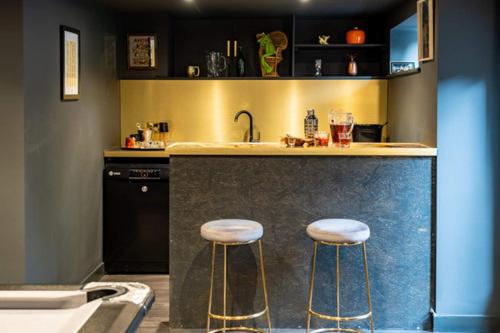 eine Küche mit zwei Barhockern und einem Waschbecken in der Unterkunft Ultimate glam, vintage central pad. Cool 70s bar. in Bournemouth