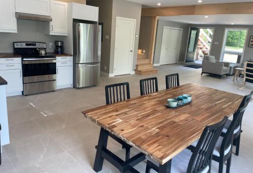 a kitchen and dining room with a wooden table and chairs at Les Chalets du Lac Grenier in Chertsey