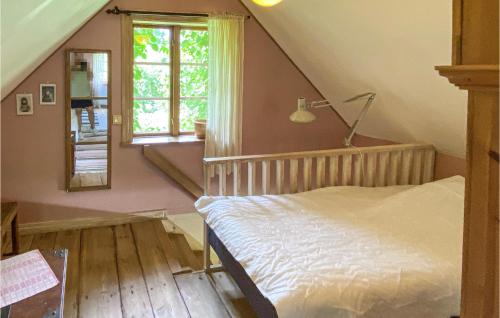 a attic bedroom with a bed and a window at Awesome Home In Trans With Kitchen in Tranås