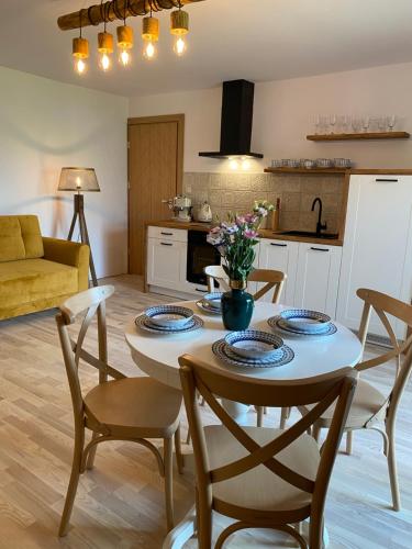 a kitchen and living room with a table and chairs at Anielski Zakątek Solina - balia z jacuzzi i sauna w cenie pobytu in Solina