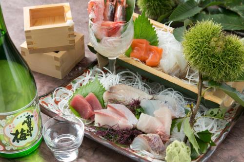 a tray filled with different types of food and a bottle of wine at Akakura Hotel in Myoko