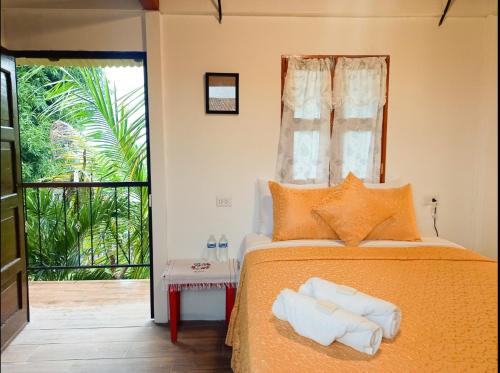 1 dormitorio con 1 cama con toallas en Hostal Koltin Suchitoto en Suchitoto