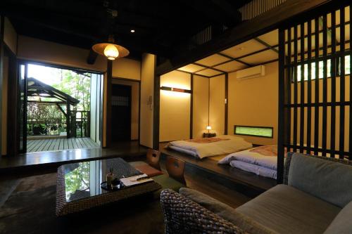 a bedroom with a bed and a table and a couch at Shinwaen in Aso