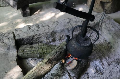 a pot on top of a stove with a fire at Shinwaen in Aso