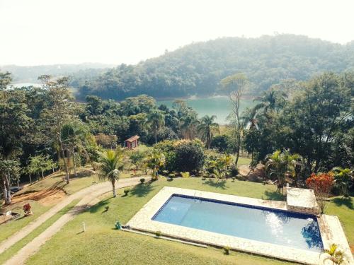 a swimming pool in a yard with a view of a lake at Recanto dos amigos ll in Igaratá