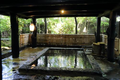 a pond in the middle of a garden at Shinwaen in Aso