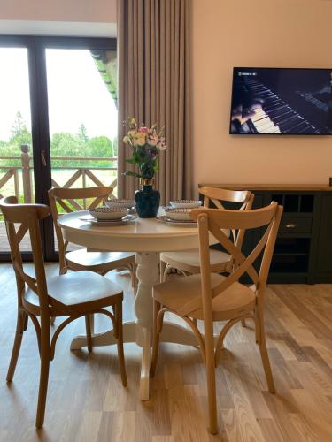 a dining room with a table and chairs and a television at Anielski Zakątek Solina - balia z jacuzzi i sauna w cenie pobytu in Solina