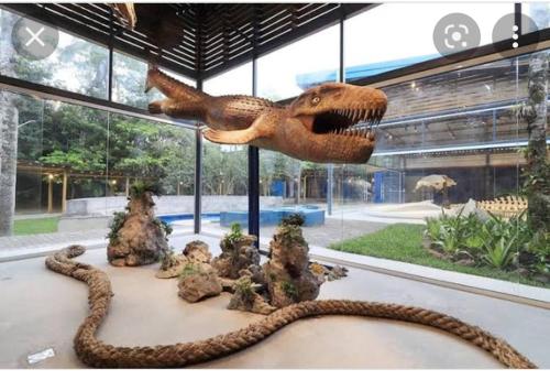 Un modelo de dinosaurio está en exhibición en un museo. en Kit Ubatuba, en Ubatuba