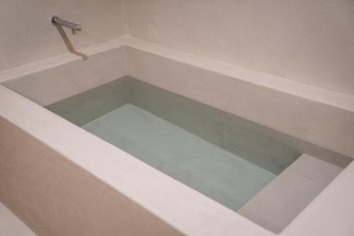a bath tub filled with water in a bathroom at SAUNALAND ASAKUSA in Tokyo