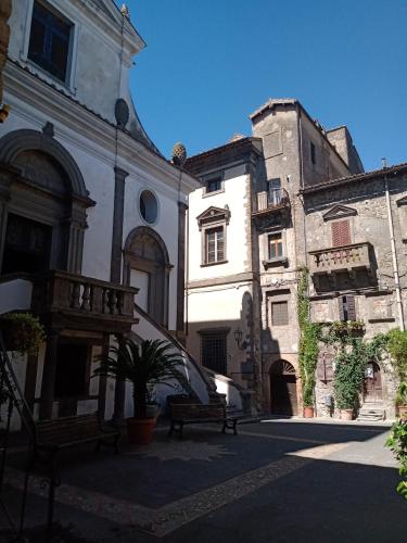 a group of buildings with a bench in a courtyard at sacrobosco apartment Ulivo in Bomarzo