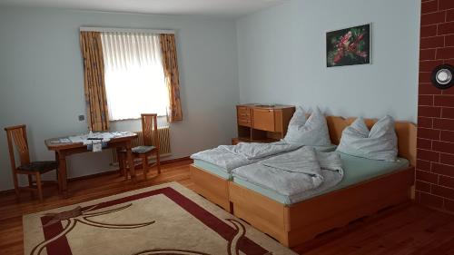 Schlafzimmer mit einem Bett, einem Tisch und einem Fenster in der Unterkunft Apartment Monsberger in Wolfsberg