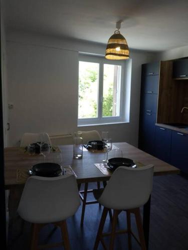 une table à manger avec des chaises, une table et une fenêtre dans l'établissement Spacieux appartement au pied de la cité médiévale, à Carcassonne