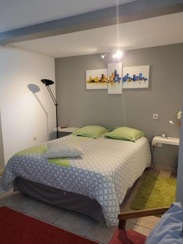 a bedroom with a large bed and a lamp at LOGIS DE NANO in Gratens