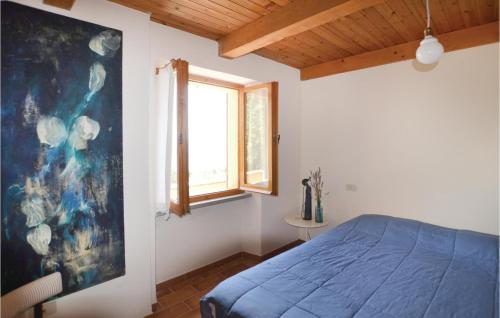 a bedroom with a blue bed and a window at Casa La Montesca in Città di Castello