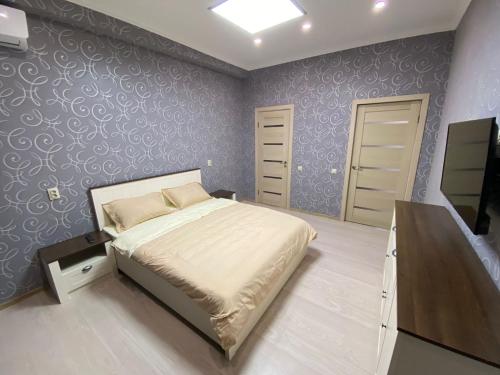 a bedroom with a bed and a dresser in it at Green Park in Aktau