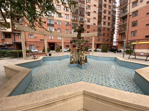 a statue of a cross in the middle of a city at Green Park in Aktau