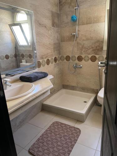 y baño con bañera, lavamanos y ducha. en Villa Telal Ain Sokhna en Ain Sokhna