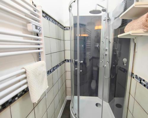 een douche in een badkamer met witte tegels bij Number 22 - Le Dorat - Apartment One in Le Dorat