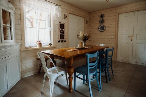 ein Esszimmer mit einem Holztisch und blauen Stühlen in der Unterkunft STACJA RUDA in Złota Wieś