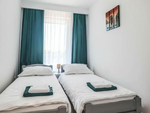 two beds in a room with a window at Nowy w centrum in Giżycko