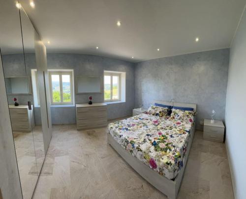 una camera da letto con un letto con copriletto floreale di IL NIDO DELLA POIANA CASA VACANZE e B & B a Montalto Pavese