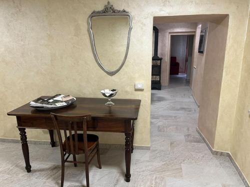 a table with a chair and a mirror on a wall at IL NIDO DELLA POIANA CASA VACANZE e B & B in Montalto Pavese
