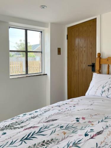 a bedroom with a bed and a window at The Hut in Ross on Wye