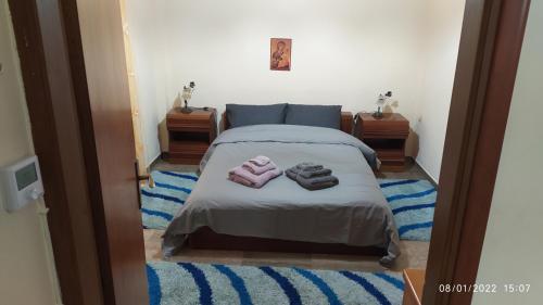 a bedroom with a bed with two towels on it at Anesis Home. in Tríkala